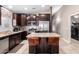 Modern kitchen featuring dark wood cabinetry, stainless steel appliances, and an island with bar seating at 39984 W Hopper Dr, Maricopa, AZ 85138