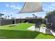 Spacious backyard with lush artificial grass, lounge furniture and shade for relaxing and entertaining guests at 4129 W Caron St, Phoenix, AZ 85051