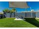 Backyard with artificial grass and seating area under a shade sail at 4129 W Caron St, Phoenix, AZ 85051