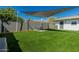 Backyard with artificial grass and seating area under a shade sail at 4129 W Caron St, Phoenix, AZ 85051