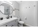 Modern bathroom featuring a round mirror, updated vanity, and walk-in shower with glass door at 4129 W Caron St, Phoenix, AZ 85051