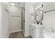 Updated bathroom featuring a shower, modern light fixture, and hexagon-shaped mirror above the vanity at 4129 W Caron St, Phoenix, AZ 85051