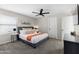 Relaxing bedroom featuring a queen size bed, side tables, ceiling fan and muted wall decor at 4129 W Caron St, Phoenix, AZ 85051