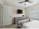Relaxing bedroom featuring a queen size bed, side tables, flat screen TV, ceiling fan and lots of light at 4129 W Caron St, Phoenix, AZ 85051