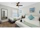 Bright bedroom featuring two twin beds, ceiling fan, beach themed decorations, and a full length mirror at 4129 W Caron St, Phoenix, AZ 85051
