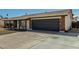 Front exterior view of a single-story home with a brick-accented facade, dark garage door, and large driveway at 4129 W Caron St, Phoenix, AZ 85051