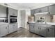 Updated kitchen with gray cabinets, stainless steel appliances, and wood-look floors, offering ample storage at 4129 W Caron St, Phoenix, AZ 85051