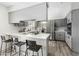 Eat-in kitchen featuring modern gray cabinets, stainless steel appliances, and stylish breakfast bar at 4129 W Caron St, Phoenix, AZ 85051