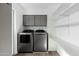 Well-organized laundry room with sleek gray cabinets, shelving, and modern washer and dryer at 4129 W Caron St, Phoenix, AZ 85051