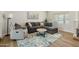 Cozy living room features a plush sofa, recliner, area rug, and bright natural light at 4129 W Caron St, Phoenix, AZ 85051