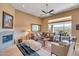 Cozy living room with a fireplace, comfortable seating, and views of the outdoor patio and landscaping at 41819 N Anthem Ridge Dr, Phoenix, AZ 85086