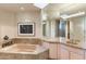 Luxurious bathroom with a soaking tub, granite countertops, a large mirror, and neutral walls at 41823 N 111Th Pl, Scottsdale, AZ 85262