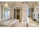 Bright bathroom featuring a jacuzzi soaking tub, dual vanities, and modern finishes at 41823 N 111Th Pl, Scottsdale, AZ 85262