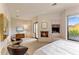 Spacious primary bedroom featuring a fireplace, sitting area, and a large window with mountain views at 41823 N 111Th Pl, Scottsdale, AZ 85262