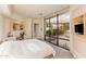 Bright bedroom with a large window overlooking a garden and a built-in desk and storage area at 41823 N 111Th Pl, Scottsdale, AZ 85262