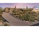 Desert home with a long driveway and native vegetation, creating a serene setting at 41823 N 111Th Pl, Scottsdale, AZ 85262