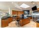 Open kitchen layout with central island, wooden cabinets, stainless steel appliances, and ample counter space at 41823 N 111Th Pl, Scottsdale, AZ 85262