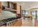 Modern kitchen with stainless steel hood, high-end appliances, and seamless transition to the dining area at 41823 N 111Th Pl, Scottsdale, AZ 85262