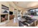 Cozy living room with a fireplace, TV, leather sofas, and seamless access to outdoor views at 41823 N 111Th Pl, Scottsdale, AZ 85262