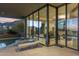 An outdoor patio featuring lounge chairs, an adjacent pool, and expansive windows at 41823 N 111Th Pl, Scottsdale, AZ 85262
