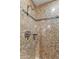 Close-up of a shower with decorative stone tile and modern shower fixtures at 41823 N 111Th Pl, Scottsdale, AZ 85262