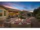 Inviting back patio featuring a fire pit with cushioned seating and desert landscaping at 42920 W Kingfisher Dr, Maricopa, AZ 85138