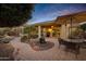 Beautiful back patio with brick pavers, outdoor dining set, water feature, and a built-in grill at 42920 W Kingfisher Dr, Maricopa, AZ 85138