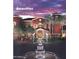 Community amenities with lush landscaping, palm trees, a water feature and a sunset sky at 42920 W Kingfisher Dr, Maricopa, AZ 85138