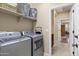 Well-equipped laundry room with modern appliances and storage shelving at 42920 W Kingfisher Dr, Maricopa, AZ 85138
