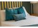 Close-up of teal colored pillows with gold trim featured in a vibrant and modern bedroom at 4617 E La Puente Ave, Phoenix, AZ 85044