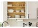 Organized kitchen cabinet showcasing bowls, plates, and cooking essentials, complemented by a subway tile backsplash at 4617 E La Puente Ave, Phoenix, AZ 85044