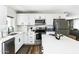 Modern kitchen featuring white cabinets, stainless steel appliances, quartz countertops and wood-look floors at 4617 E La Puente Ave, Phoenix, AZ 85044