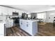 Bright kitchen with stainless steel appliances, white cabinets, quartz countertops, and a central island with drawer storage at 4617 E La Puente Ave, Phoenix, AZ 85044