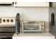 Close-up of countertop featuring a stainless-steel toaster oven, knife block, and utensil holder, set against a subway tile backsplash at 4617 E La Puente Ave, Phoenix, AZ 85044