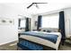 Comfortable main bedroom with neutral carpet, mirrored closet doors, fan and bed dressed in blue accents at 4617 E La Puente Ave, Phoenix, AZ 85044