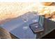 Close-up of a patio table featuring wine glasses and a cocktail recipe book, ideal for outdoor enjoyment at 4617 E La Puente Ave, Phoenix, AZ 85044