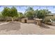 Backyard with stone patio, outdoor kitchen, bar seating, lush trees and green shrubs at 4665 E Dartmouth St, Mesa, AZ 85205