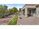 Spacious backyard with covered patio, putting green, lush landscaping, brick patio and bench at 4665 E Dartmouth St, Mesa, AZ 85205