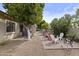 Backyard with stone patio, outdoor seating, trees, shrubs and putting green at 4665 E Dartmouth St, Mesa, AZ 85205
