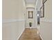 Hallway with hardwood floors, chair rail, neutral walls, and a decorative mirror at 4665 E Dartmouth St, Mesa, AZ 85205