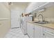 Bright laundry room featuring white cabinets, sink, and a modern washer and dryer at 4665 E Dartmouth St, Mesa, AZ 85205