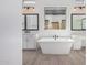 Bright bathroom with a freestanding tub centered between two vanities and mirrors at 5747 E Star Valley St, Mesa, AZ 85215
