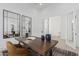 Home office with rustic wood desk, modern mirror, and leather chair at 5747 E Star Valley St, Mesa, AZ 85215