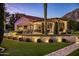 Picturesque backyard with outdoor kitchen, lush landscaping, and cozy lighting at 5902 E Arcadia Ln, Phoenix, AZ 85018