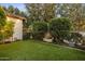 Well-maintained backyard featuring lush artificial turf, mature trees, manicured bushes, and a charming water feature at 5902 E Arcadia Ln, Phoenix, AZ 85018