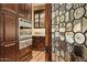 Butler's pantry with custom wood cabinets, marble countertops, and high-end appliances at 5902 E Arcadia Ln, Phoenix, AZ 85018
