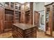Elaborate walk-in closet with a wooden ladder, cabinets, shelves, and a center island at 5902 E Arcadia Ln, Phoenix, AZ 85018