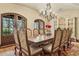 Formal dining room with large wooden table, seating for ten, and elegant chandelier at 5902 E Arcadia Ln, Phoenix, AZ 85018