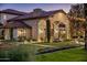 Elegant home exterior with stone accents, arched entries, and manicured landscaping at 5902 E Arcadia Ln, Phoenix, AZ 85018