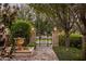 A walkway with an ornate fountain leads to an iron gate framed by stone pillars and lush landscaping at 5902 E Arcadia Ln, Phoenix, AZ 85018
